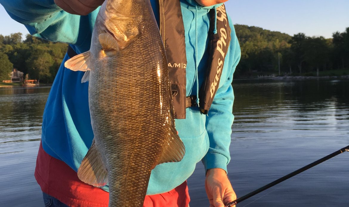 Roane Transportation truck driver, Tim Larue, holding up a fish after catching it.